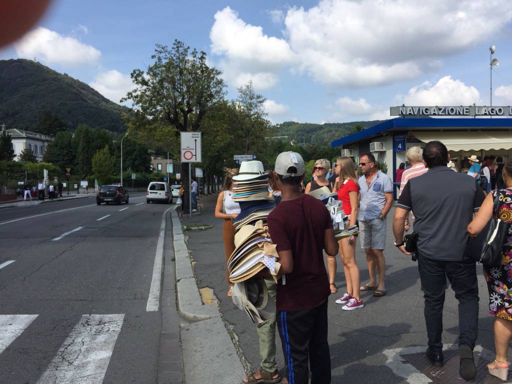 venditori abusivi di cappelli sul lungolago di como tanti anche oggi