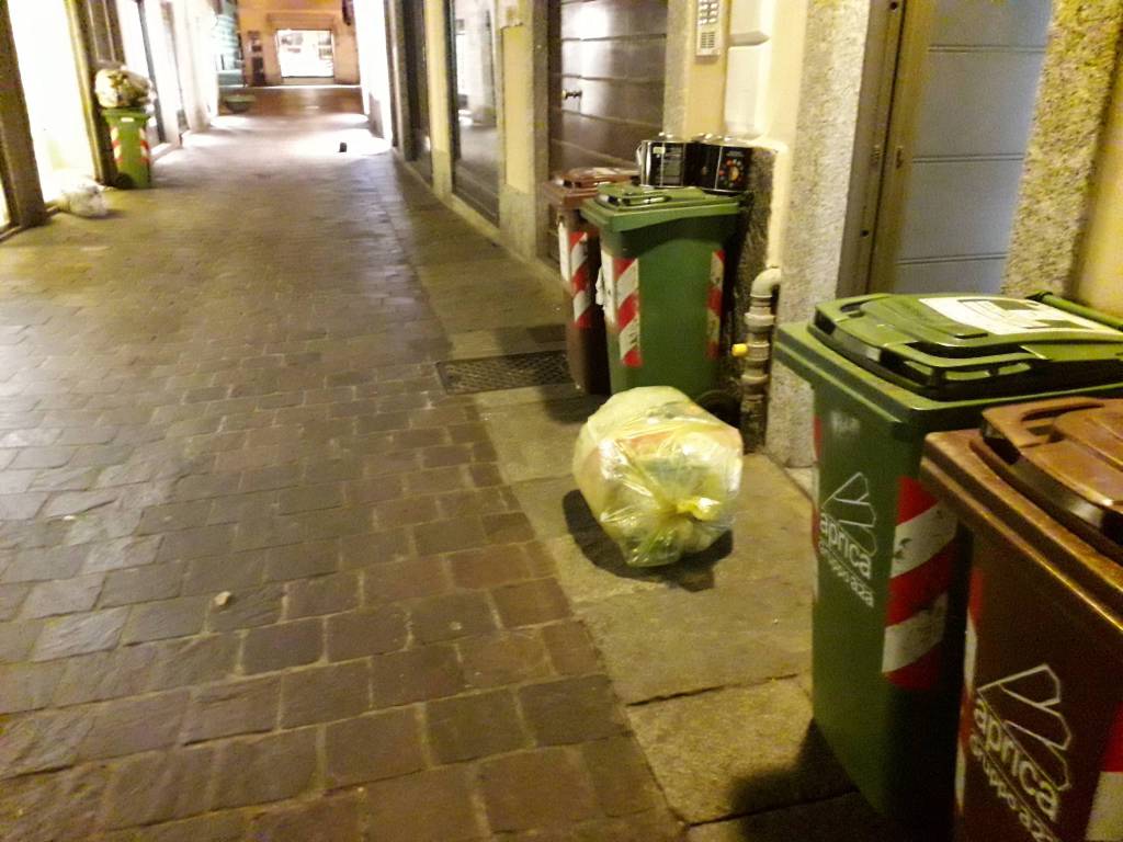 sacchi rifiuti sparsi sulle strade di como per il vento forte notte