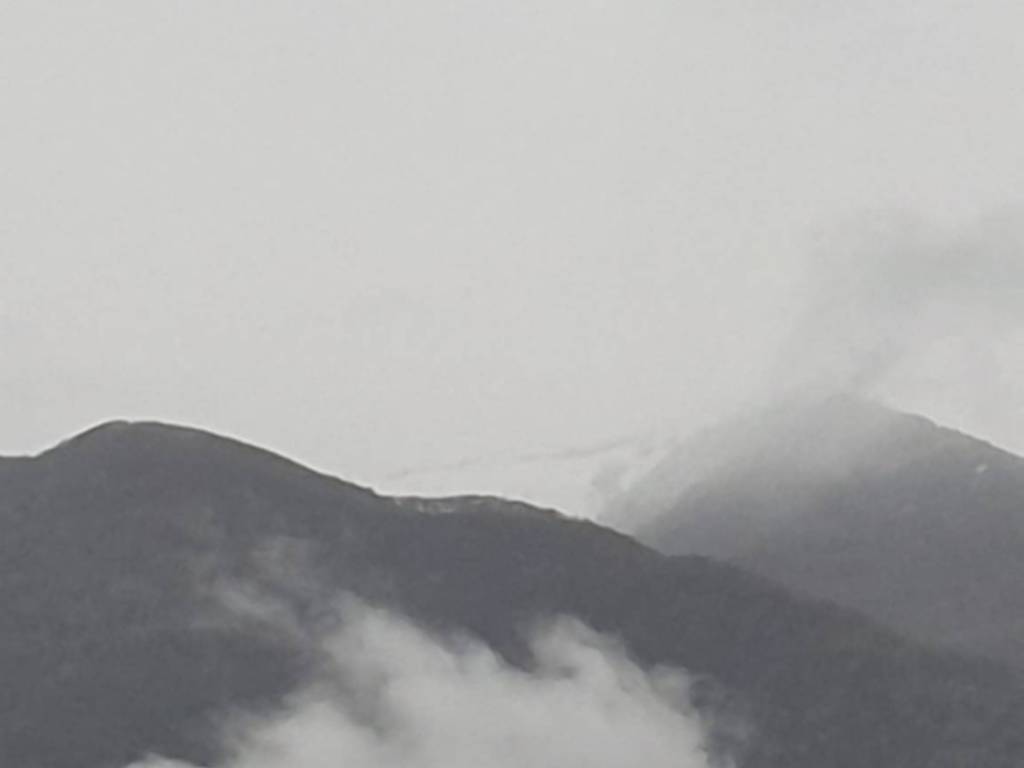 monte san primo innevato tra le nuvole