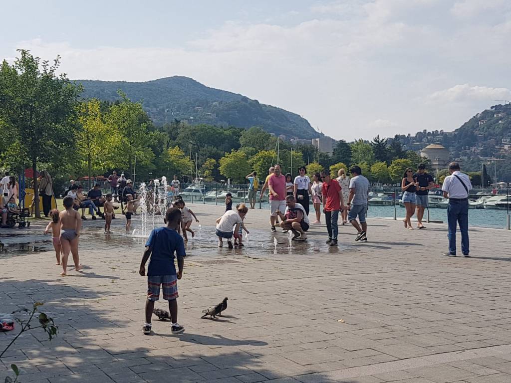 caldo e turisti como gente su lungolago e diga foranea