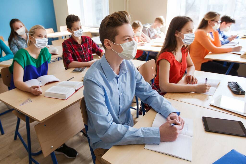 studenti classe ripartenza anno scolastico post covid con mascherine