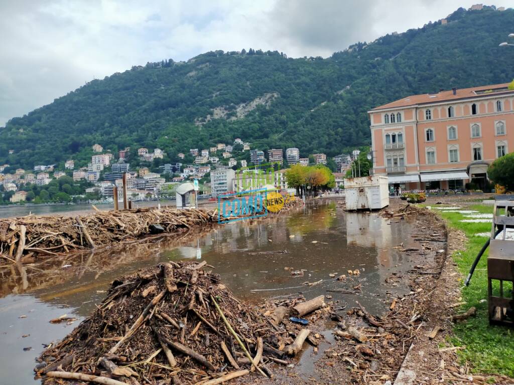 ultimi lavori per rimuovere detriti sul lungolago di como dopo esondazione