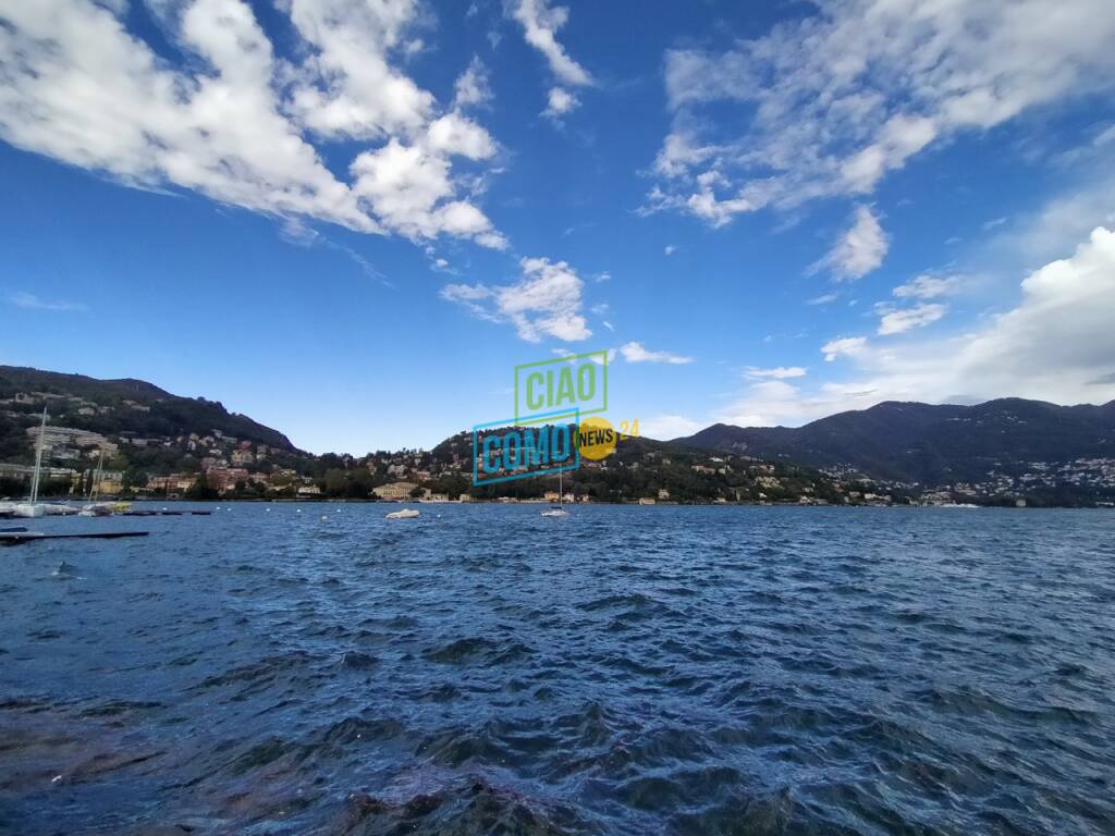 lago increspato per vento raffiche forti crescita livello e cielo con sereno e nuvole