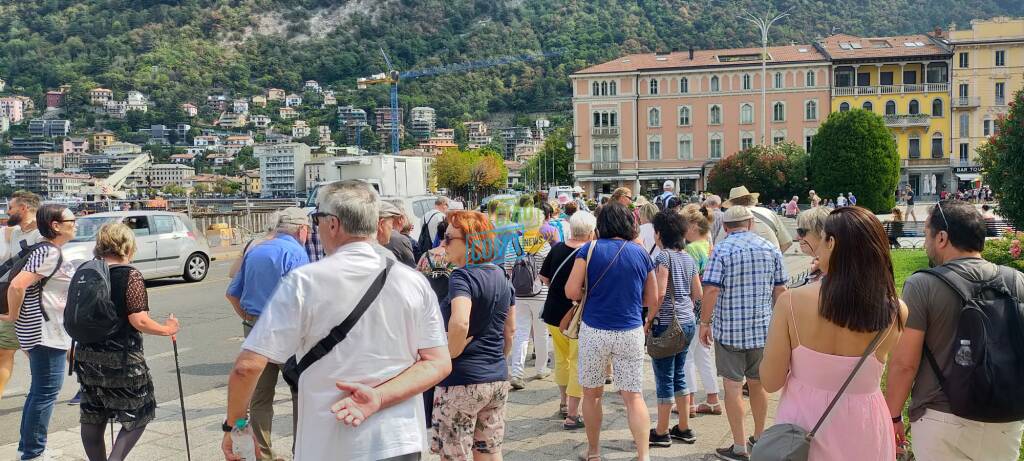 turisti como in attesa dei battelli sul lungolago code e turisti piazza cavour