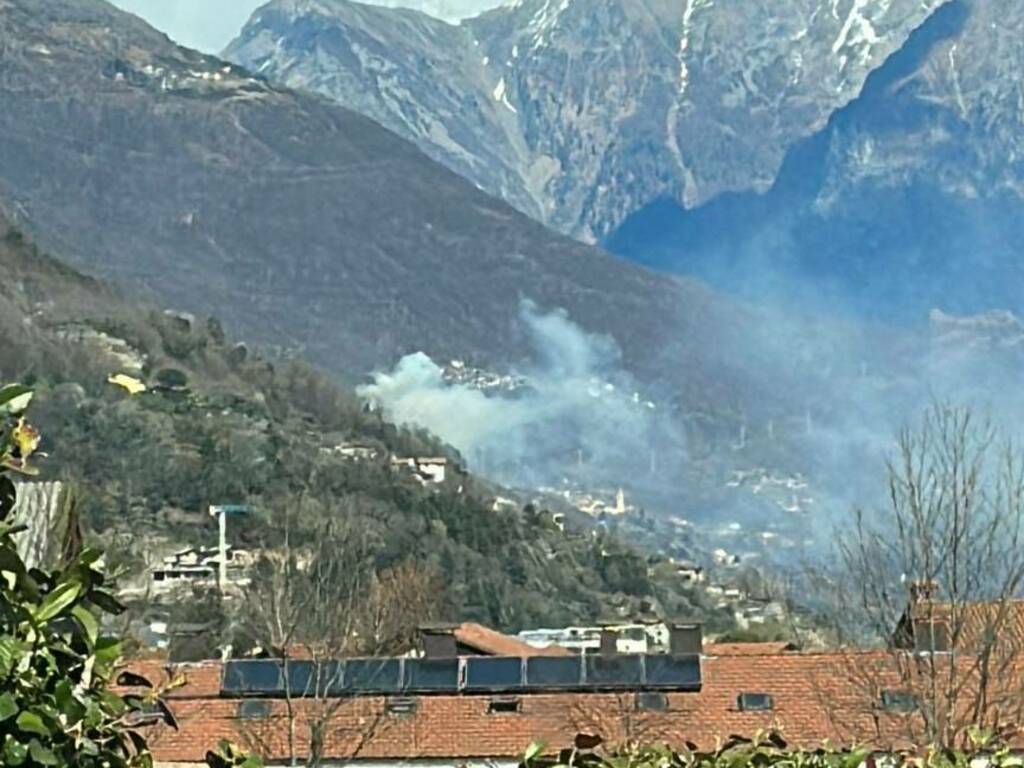 incendio a montemezzo boschi colonna funo visibile da distane e vigili del fuoco in posto